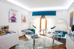 a white living room with tables and chairs at Isa Guest Rooms in Naples