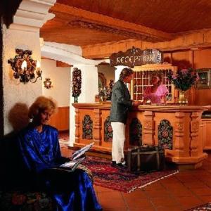 un hombre y una mujer sentados en un mostrador en una cocina en Pension Almrausch en Neustift im Stubaital