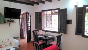 a living room with a table and chairs and windows at Casa Dos Barrancos in Santa Cruz de Tenerife