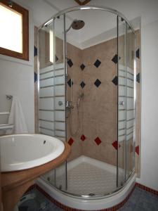 a bathroom with a shower and a tub and a sink at Polikandia Hotel in Chora Folegandros +37 photos