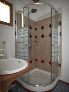 a bathroom with a shower and a tub and a sink at Polikandia Hotel in Chora Folegandros