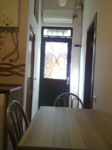 una mesa con sillas y una puerta con ventana en Vita, en Tiflis