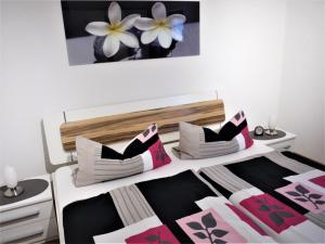 een slaapkamer met een bed met een zwart-witte deken bij Sterne-Ferienwohnung-Apartment Regnitztal in Buttenheim