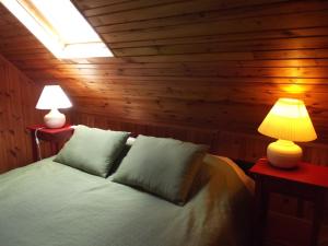 een slaapkamer met een bed met twee lampen op twee tafels bij Qubalonka Saunarium Bory Tucholskie in Bak
