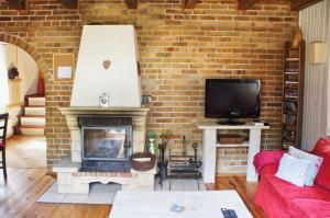 a living room with a brick wall and a fireplace at Qubalonka Saunarium Bory Tucholskie in Karsin