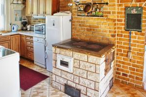 a kitchen with a brick wall with an oven at Qubalonka Saunarium Bory Tucholskie in Karsin