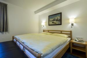 een bed in een kamer met twee lampen aan de muur bij Am Eschenbichl in Mayrhofen