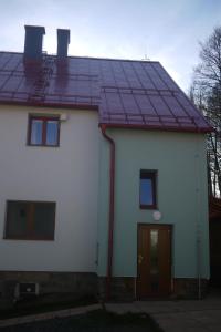 Casa blanca con paneles solares en el techo en Apartmán Fydorka, en Jeseník