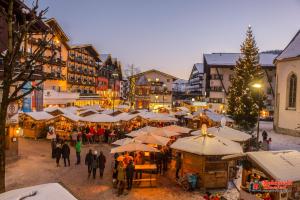 a group of people walking around a christmas market at Das Aparthotel Olympia Tirol in Seefeld in Tirol