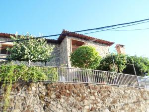a house on top of a stone wall at Las Glicinias del Jerte in Casas del Castañar