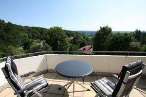 a patio with a table and chairs on a balcony at Ferienhaus am Kaufunger Wald in Kaufungen