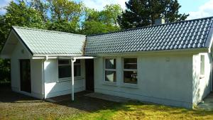 una piccola casa bianca con tetto di Cosy Lakeside Cottage John's hollow a Headford