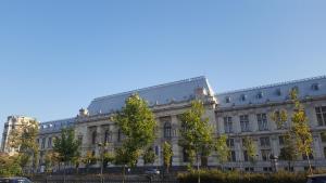 a large white building with trees in front of it at Hospitality Centrum- River in Bucharest