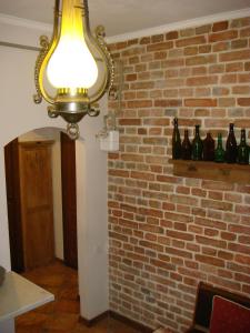 uma luz numa parede de tijolos com garrafas numa prateleira em Kufer Flat em Lviv