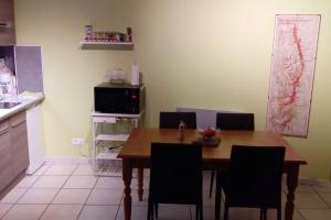a kitchen with a wooden table and chairs in a kitchen at Le Jim : Rue Musette in Dijon