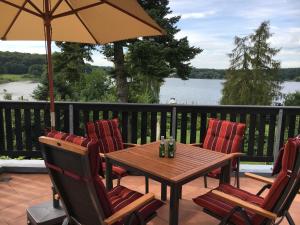 a wooden table and chairs with an umbrella on a deck at Potsdam-Krampnitz in Potsdam