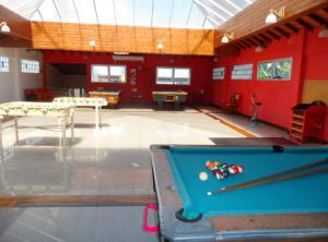 a pool table in a room with red walls at Hotel Eo Park in San Clemente del Tuyú