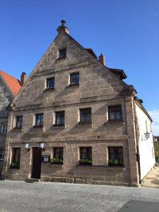 an old stone building with windows on a street at Altstadtpension Zirndorf in Zirndorf