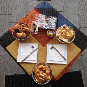 - une table avec des bols de nourriture et des paniers de viennoiseries dans l'établissement I Tre Merli Locanda, à Camogli