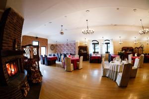 a dining room with tables and chairs and a fireplace at Pod Lipami in Bystra