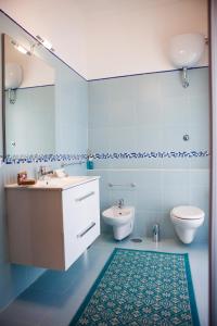uma casa de banho azul com um lavatório e um WC em Isa Guest Rooms em Nápoles