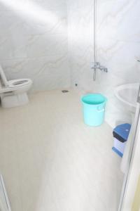 ein Badezimmer mit einem WC und einem blauen Eimer in der Unterkunft Hanh Mai Hotel in Phu Quoc