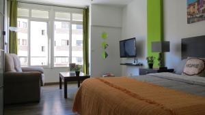 1 dormitorio con cama, sofá y TV en Apartamento Rulosol 1, en Torremolinos