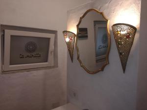 a bathroom with two lights and a mirror on the wall at La Mirilla Suites 2 in Tarifa
