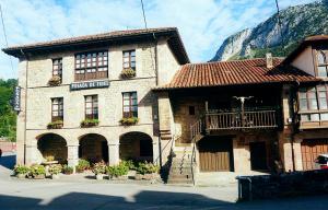 a building in front of a mountain at Posada de Fidel in Puentenansa