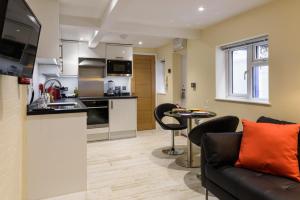 a kitchen and living room with a couch and a table at 5b North Parade Avenue in Oxford +14 photos