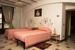 - une chambre avec 2 lits avec des draps roses dans l'établissement La Madonnina Agriturismo Dorè, à Alba