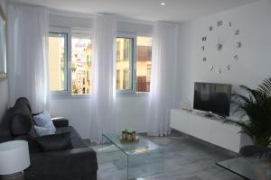 sala de estar con sofá y TV en Atarazana Apartment, en Málaga
