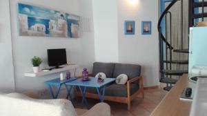 un soggiorno con tavolo blu e divano di la casa de Isabel a Níjar