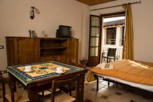 Cette chambre comprend une table, un lit et une télévision. dans l'établissement La Madonnina Agriturismo Dorè, à Alba