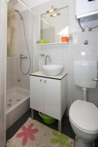 een witte badkamer met een wastafel en een toilet bij Apartment Zorica in Omiš