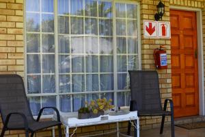 a window with two chairs and a table in front of it at Avant Garde Lodge in Kempton Park