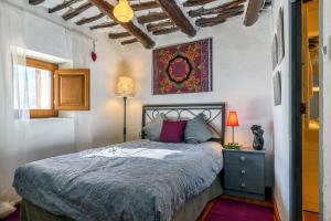 a bedroom with a bed and a painting on the wall at Casa Amaranta in Capileira