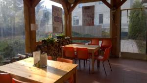 een restaurant met houten tafels, stoelen en ramen bij Penzion Lipůvka in Lipova Lazne
