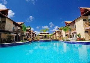 een groot blauw zwembad in een resort bij Bangalô com área de lazer estilo resort in Cabedelo