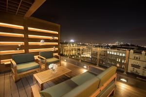 a balcony with a couch and two chairs and a table at Eden Luxury Suites Terazije in Belgrade