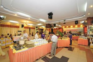 un grupo de personas de pie en mesas de buffet en un restaurante en Duy Tan Hotel, en Hue