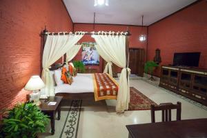 a bedroom with a bed with curtains and a television at The Grand Imperial - Heritage Hotel in Agra