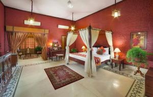 a bedroom with a bed and a red wall at The Grand Imperial - Heritage Hotel in Agra