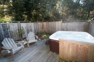 a hot tub and two chairs on a deck at Redwood Cottage in Mendocino
