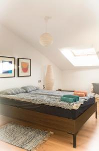 uma cama grande num quarto com uma clarabóia em Ático Lobariñas em Allariz