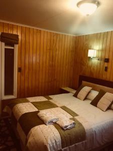 a bedroom with a large bed with wooden walls at Hotel Yellow Submarine in Punta Arenas