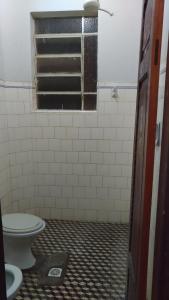 a bathroom with a toilet and a window at Hotel Indaiá in Governador Valadares