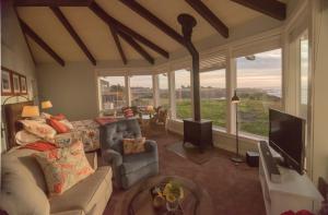 a living room with a couch and a tv at Cliff House at Otter Point in Mendocino
