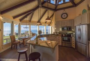 a large kitchen with a table and a dining room at Cliff House at Otter Point in Mendocino