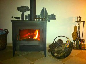 a blue stove with a fire in a room at Os 5 Sentidos in Mourão